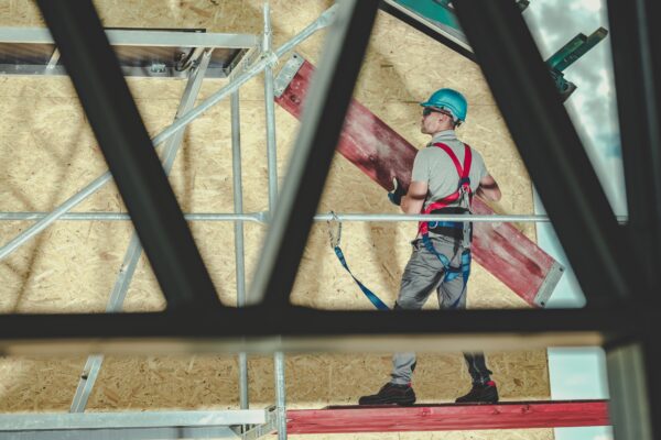 Construction Industry. Caucasian Contractor Worker Installing Scaffolding Moving Wooden Path Elements.